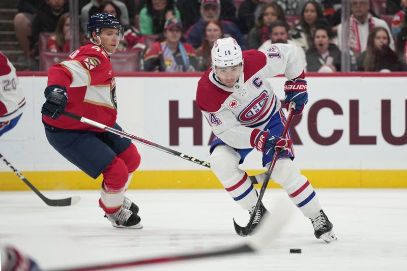 Dec 30, 2023; Sunrise, Florida, USA; Montreal Canadiens center Nick Suzuki (14) looks to make a pass as Florida Panthers defenseman Gustav Forsling (42) defends during the first period at Amerant Bank Arena. Mandatory Credit: Jim Rassol-USA TODAY Sports