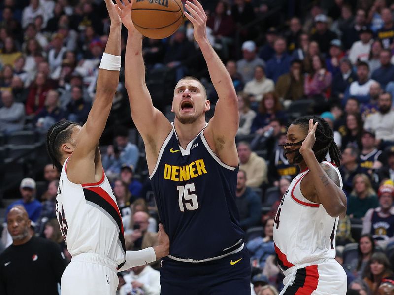 DENVER, COLORADO - FEBRUARY 12: Nikola Jokic #15 of the Denver Nuggets is fouled going to the basket against Toumani Camaram #33 and Jabari Walker #34 of the Portland Trail Blazers in the first quarter at Ball Arena on February 12, 2025 in Denver, Colorado. NOTE TO USER: User expressly acknowledges and agrees that, by downloading and or using this photograph, User is consenting to the terms and conditions of the Getty Images License Agreement.   (Photo by Matthew Stockman/Getty Images)