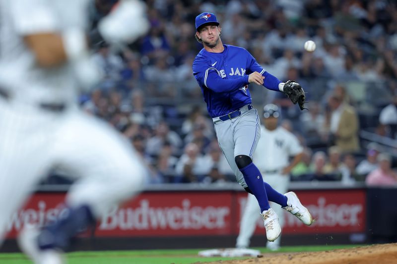 Sep 5, 2025; Bronx, New York, USA; Toronto Blue Jays third baseman Ernie Clement (22) throws out New York Yankees shortstop Jose Caballero (72) on a bunt attempt during the third inning at Yankee Stadium. Mandatory Credit: Brad Penner-Imagn Images