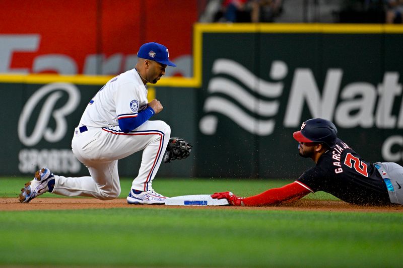 May 2, 2024; Arlington, Texas, USA; Washington Nationals second baseman Luis Garcia Jr. (2) slides under the tag of Texas Rangers second baseman Marcus Semien (2) for a double during the first inning at Globe Life Field. Mandatory Credit: Jerome Miron-USA TODAY Sports