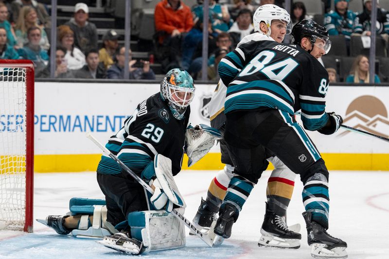 Feb 19, 2024; San Jose, California, USA; Vegas Golden Knights left wing Mason Morelli (11) and San Jose Sharks defenseman Jan Rutta (84) battle for position in front of San Jose Sharks goalie Mackenzie Blackwood (29) during the third period at SAP Center at San Jose. Mandatory Credit: Neville E. Guard-USA TODAY Sports