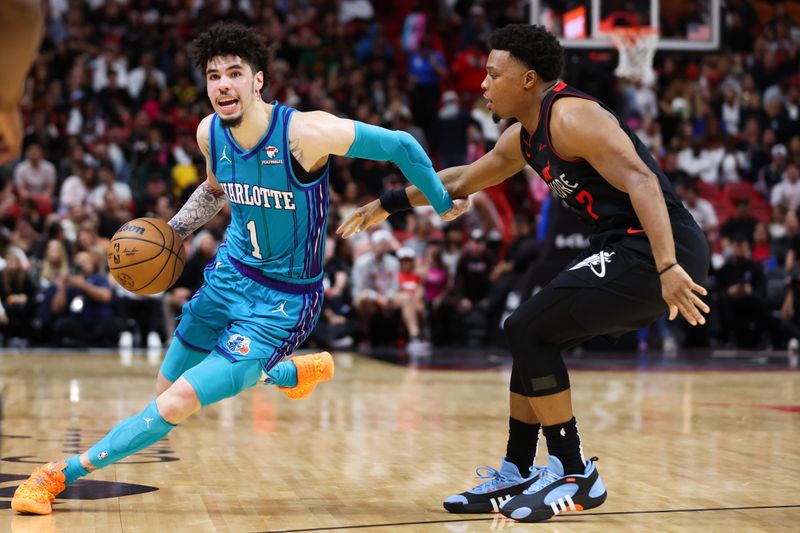 MIAMI, FLORIDA - JANUARY 14: LaMelo Ball #1 of the Charlotte Hornets drives against Kyle Lowry #7 of the Miami Heat during the fourth quarter at Kaseya Center on January 14, 2024 in Miami, Florida. NOTE TO USER: User expressly acknowledges and agrees that, by downloading and or using this photograph, User is consenting to the terms and conditions of the Getty Images License Agreement.  (Photo by Megan Briggs/Getty Images)