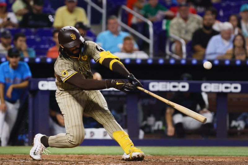 Aug 11, 2024; Miami, Florida, USA; San Diego Padres catcher Luis Campusano (12) hits a single against the Miami Marlins during the sixth inning at loanDepot Park. Mandatory Credit: Sam Navarro-USA TODAY Sports