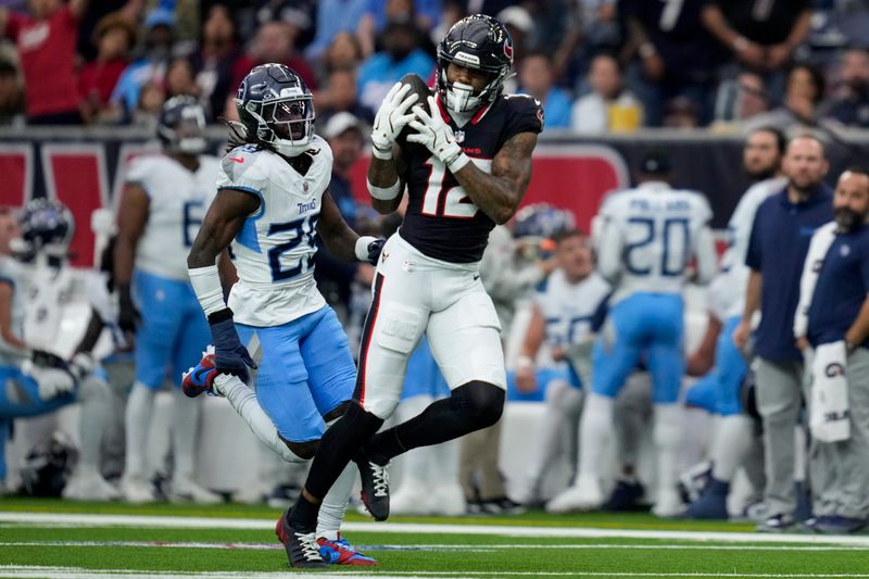 Houston Texans wide receiver Nico Collins (12) makes a catch past Tennessee Titans cornerback Jarvis Brownlee Jr., left, during the first half of an NFL football game Sunday, Nov. 24, 2024, in Houston. (AP Photo/Ashley Landis)