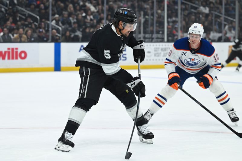 Feb 26, 2026; Los Angeles, California, USA; Los Angeles Kings defenseman Cody Ceci (5) looks to pass the puck against Edmonton Oilers center Trent Frederic (10) during the first period at Crypto.com Arena. Mandatory Credit: Griffin Hooper-Imagn Images  