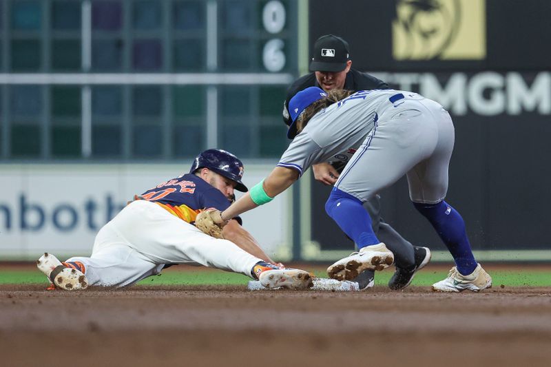 Apr 2, 2024; Houston, Texas, USA; Toronto Blue Jays shortstop Bo Bichette (11) tags out Houston Astros center fielder Chas McCormick (20) on a play at second base during the third inning at Minute Maid Park. Mandatory Credit: Troy Taormina-USA TODAY Sports