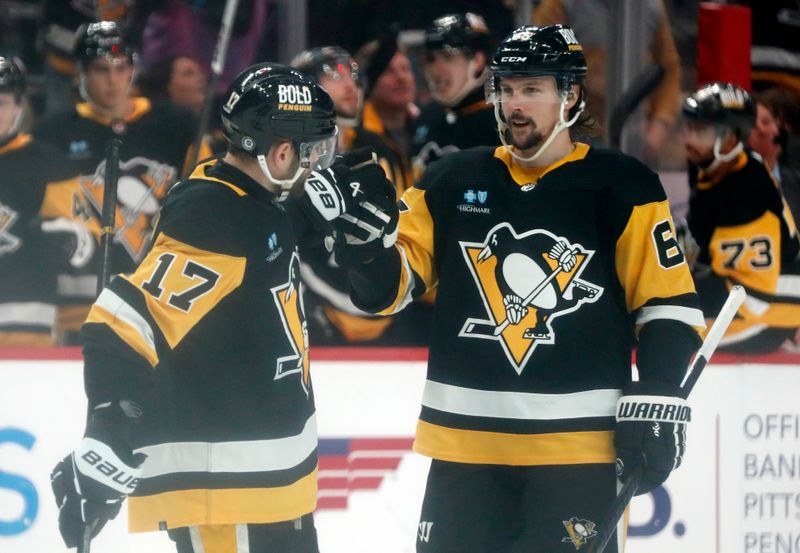 Mar 26, 2024; Pittsburgh, Pennsylvania, USA; Pittsburgh Penguins right wing Bryan Rust (17) celebrates his goal with Penguins defenseman Erik Karlsson (65) against the Carolina Hurricanes during the second period at PPG Paints Arena. Mandatory Credit: Charles LeClaire-USA TODAY Sports