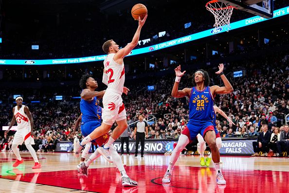 TORONTO, ON - DECEMBER 20: Malachi Flynn #22 of the Toronto Raptors goes to the baskett aginst Zeke Nnaji #22 of the Denver Nuggets during the second half at Scotiabank Arena on December 20, 2023 in Toronto, Ontario, Canada. NOTE TO USER: User expressly acknowledges and agrees that, by downloading and/or using this Photograph, user is consenting to the terms and conditions of the Getty Images License Agreement. (Photo by Andrew Lahodynskyj/Getty Images)