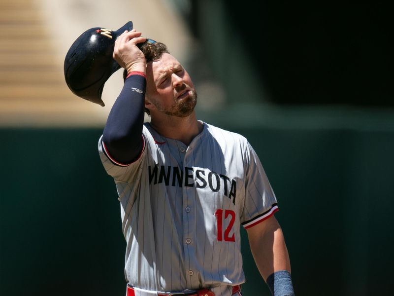 Jun 23, 2024; Oakland, California, USA; Minnesota Twins second baseman Kyle Farmer (12) reacts to being caught stealing during the seventh inning against the Oakland Athletics at Oakland-Alameda County Coliseum. Mandatory Credit: D. Ross Cameron-USA TODAY Sports