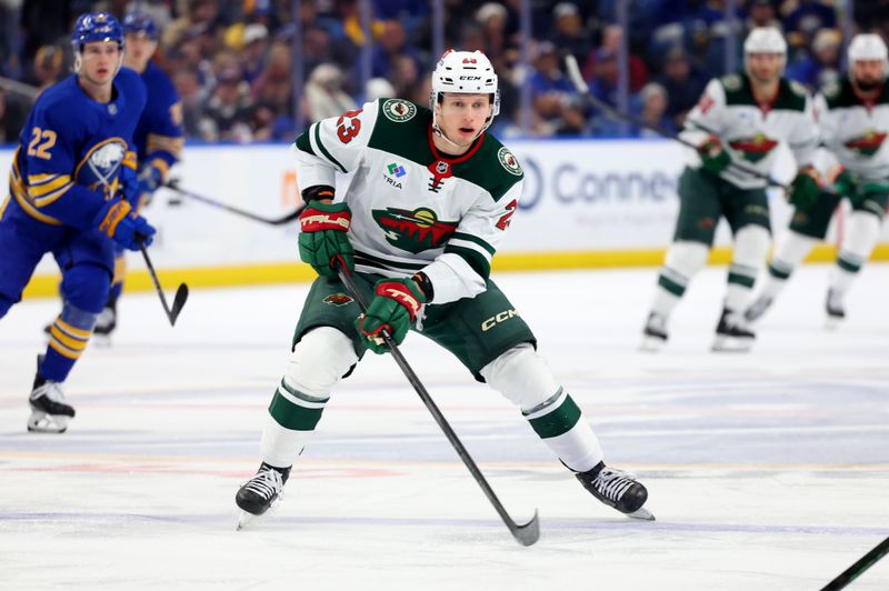 Nov 27, 2024; Buffalo, New York, USA;  Minnesota Wild center Marco Rossi (23) carries the puck up ice during the third period against the Buffalo Sabres at KeyBank Center. Mandatory Credit: Timothy T. Ludwig-Imagn Images