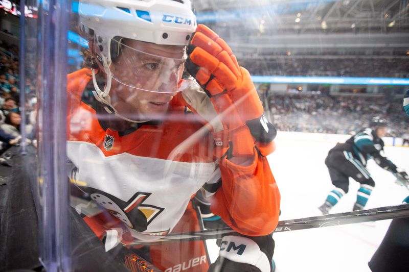 Oct 12, 2024; San Jose, California, USA; Anaheim Ducks left winger Brock McGinn (26) is checked against the boards by a San Jose Sharks player during the second period at SAP Center at San Jose. Mandatory Credit: D. Ross Cameron-Imagn Images