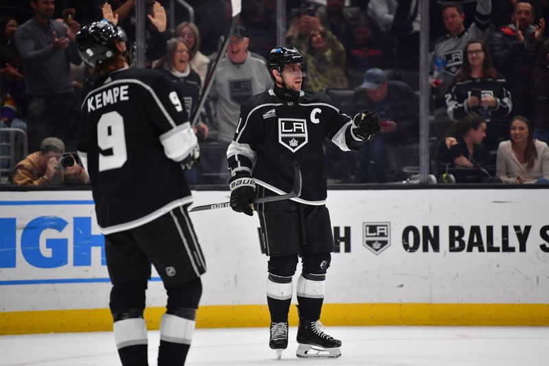 Mar 20, 2024; Los Angeles, California, USA; Los Angeles Kings center Anze Kopitar (11) celebrates his goal scored against the Minnesota Wild with right wing Adrian Kempe (9) during the second period at Crypto.com Arena. Mandatory Credit: Gary A. Vasquez-USA TODAY Sports