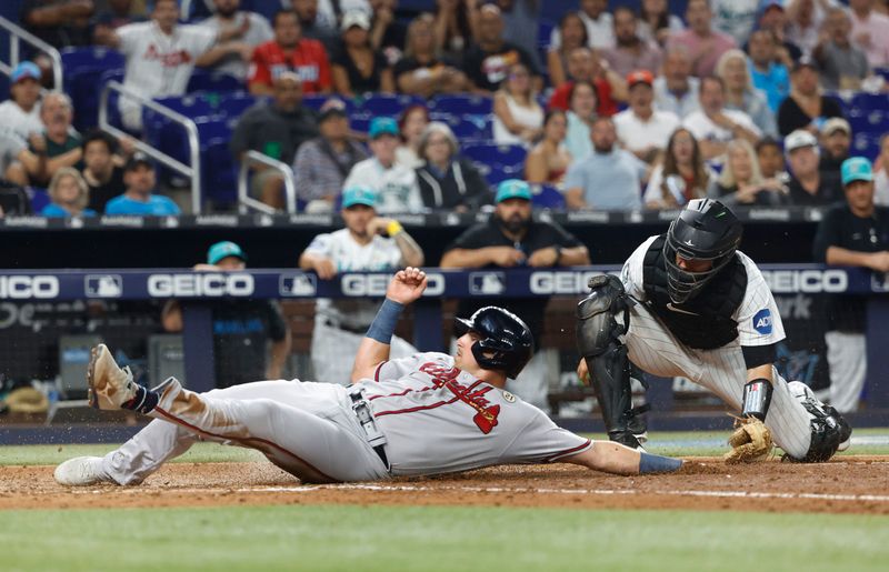 Sep 15, 2023; Miami, Florida, USA; Atlanta Braves third baseman Austin Riley (27) is safe at the plate around the tag of Miami Marlins catcher Jacob Stallings (58) during the fifth ining at loanDepot Park. Mandatory Credit: Rhona Wise-USA TODAY Sports