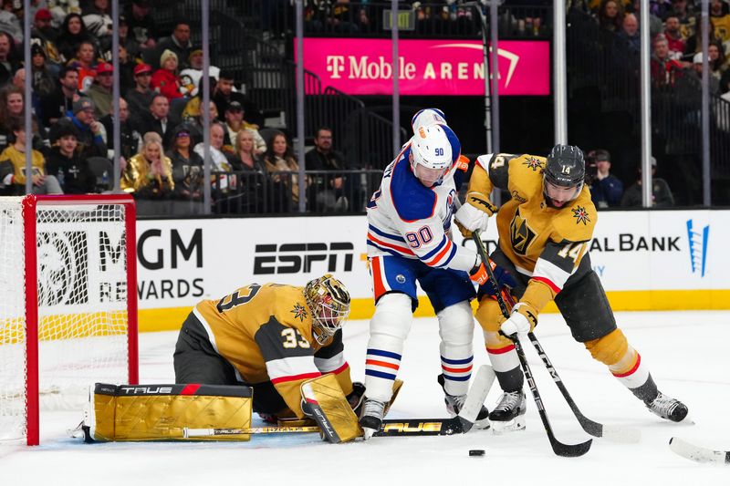 Feb 6, 2024; Las Vegas, Nevada, USA; Vegas Golden Knights defenseman Nicolas Hague (14) ties up the stick of Edmonton Oilers right wing Corey Perry (90) as Vegas Golden Knights goaltender Adin Hill (33) defends his net during the second net at T-Mobile Arena. Mandatory Credit: Stephen R. Sylvanie-USA TODAY Sports