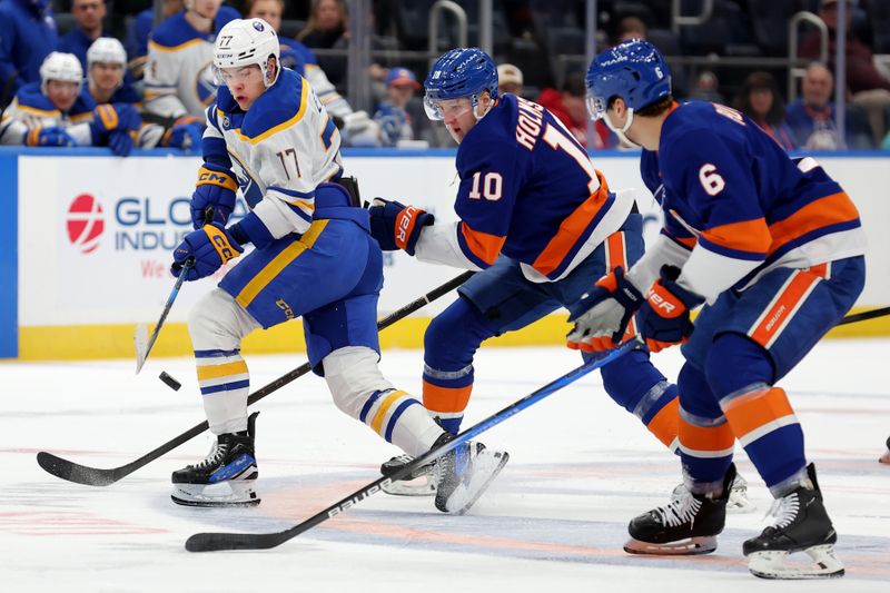 Nov 30, 2024; Elmont, New York, USA; Buffalo Sabres right wing JJ Peterka (77) plays the puck against New York Islanders right wing Simon Holmstrom (10) and defenseman Ryan Pulock (6) during the first period at UBS Arena. Mandatory Credit: Brad Penner-Imagn Images