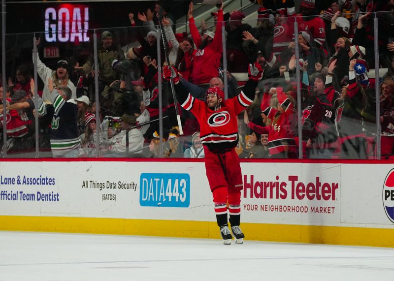 Jan 13, 2024; Raleigh, North Carolina, USA;  Carolina Hurricanes defenseman Brett Pesce (22) celebrates his game winning goal in the overtime against the Pittsburgh Penguins at PNC Arena. Mandatory Credit: James Guillory-USA TODAY Sports