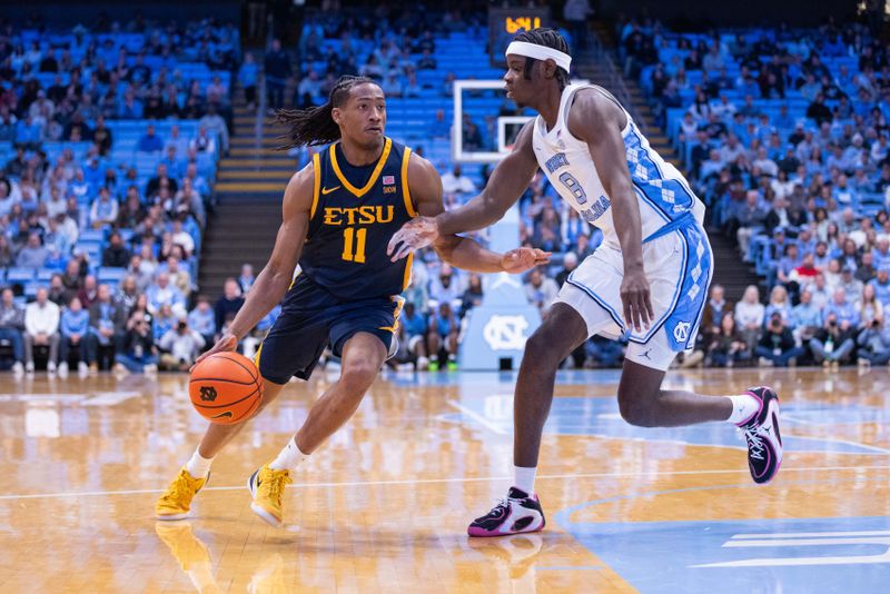 Dec 16, 2025; Chapel Hill, North Carolina, USA; ETSU Buccaneers guard Brian Taylor (11) drives on North Carolina Tar Heels forward Caleb Wilson (8) during the first half at Dean E. Smith Center. Mandatory Credit: Scott Kinser-Imagn Images