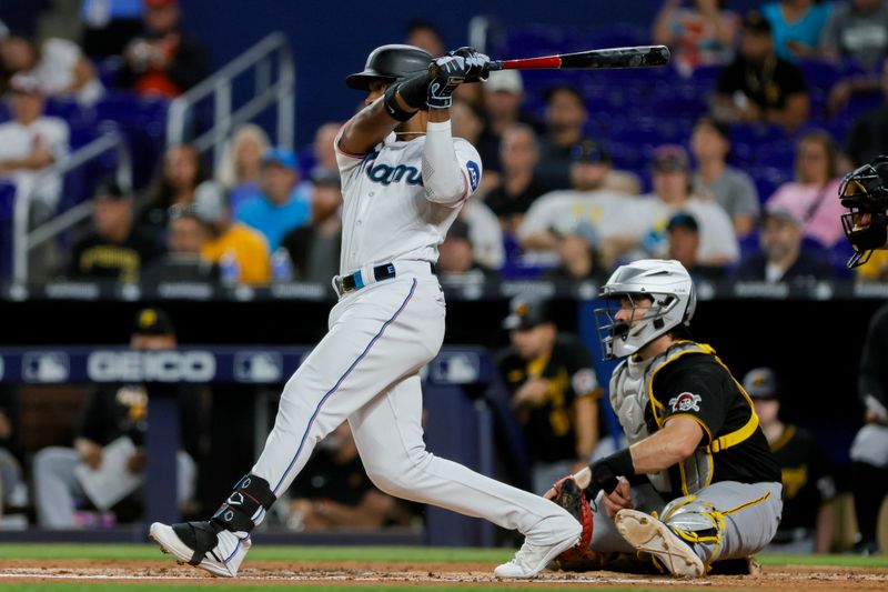 Jun 25, 2023; Miami, Florida, USA; Miami Marlins left fielder Bryan De La Cruz (14) hits a single against the Pittsburgh Pirates during the first inning at loanDepot Park. Mandatory Credit: Sam Navarro-USA TODAY Sports