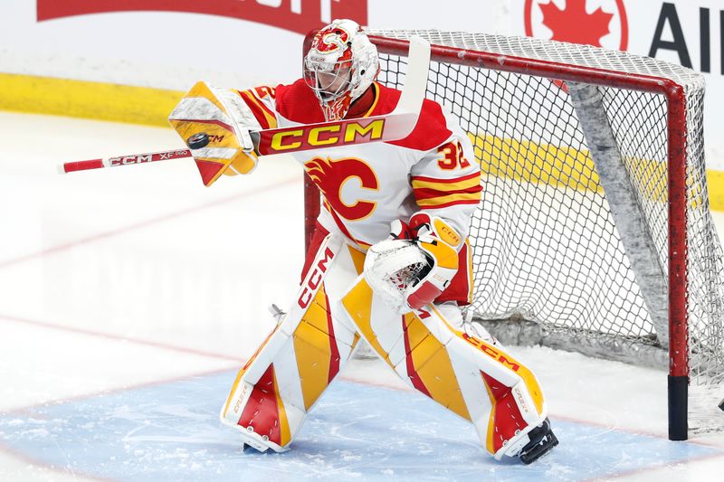 Apr 4, 2024; Winnipeg, Manitoba, CAN; Calgary Flames goaltender Dustin Wolf (32) warms up before a game against the Winnipeg Jets at Canada Life Centre. Mandatory Credit: James Carey Lauder-USA TODAY Sports