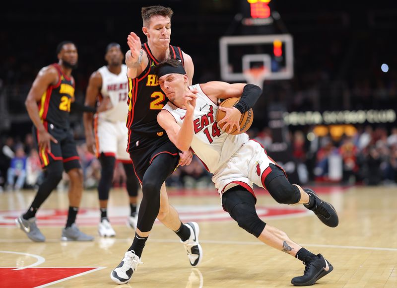 ATLANTA, GEORGIA - APRIL 09:  Tyler Herro #14 of the Miami Heat draws a foul as he drives into Vit Krejci #27 of the Atlanta Hawks during the second quarter at State Farm Arena on April 09, 2024 in Atlanta, Georgia.  NOTE TO USER: User expressly acknowledges and agrees that, by downloading and/or using this photograph, user is consenting to the terms and conditions of the Getty Images License Agreement.  (Photo by Kevin C. Cox/Getty Images)