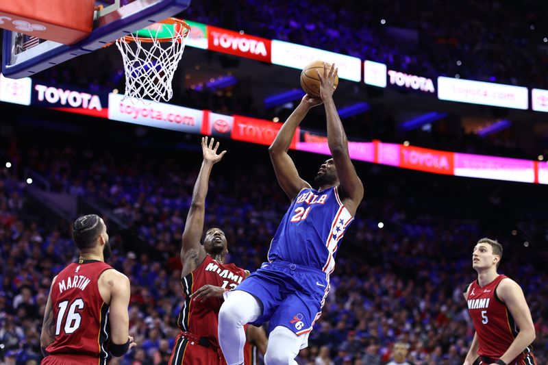 PHILADELPHIA, PENNSYLVANIA - APRIL 17: Joel Embiid #21 of the Philadelphia 76ers shoots over Bam Adebayo #13 of the Miami Heat during the first quarter of the Eastern Conference Play-In Tournament at the Wells Fargo Center on April 17, 2024 in Philadelphia, Pennsylvania. NOTE TO USER: User expressly acknowledges and agrees that, by downloading and or using this photograph, User is consenting to the terms and conditions of the Getty Images License Agreement. (Photo by Tim Nwachukwu/Getty Images)