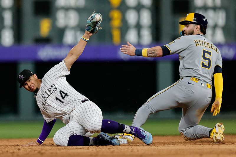 Apr 9, 2025; Denver, Colorado, USA; Colorado Rockies shortstop Ezequiel Tovar (14) fields a throw as Milwaukee Brewers center fielder Garrett Mitchell (5) safely steals second in the fifth inning at Coors Field. Mandatory Credit: Isaiah J. Downing-Imagn Images