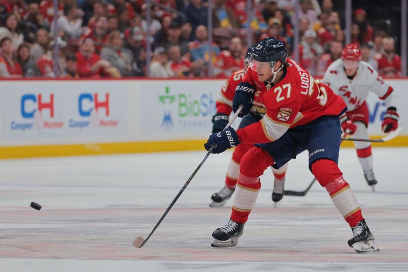 Nov 30, 2024; Sunrise, Florida, USA; Florida Panthers center Eetu Luostarinen (27) moves the puck against the Carolina Hurricanes during the second period at Amerant Bank Arena. Mandatory Credit: Sam Navarro-Imagn Images