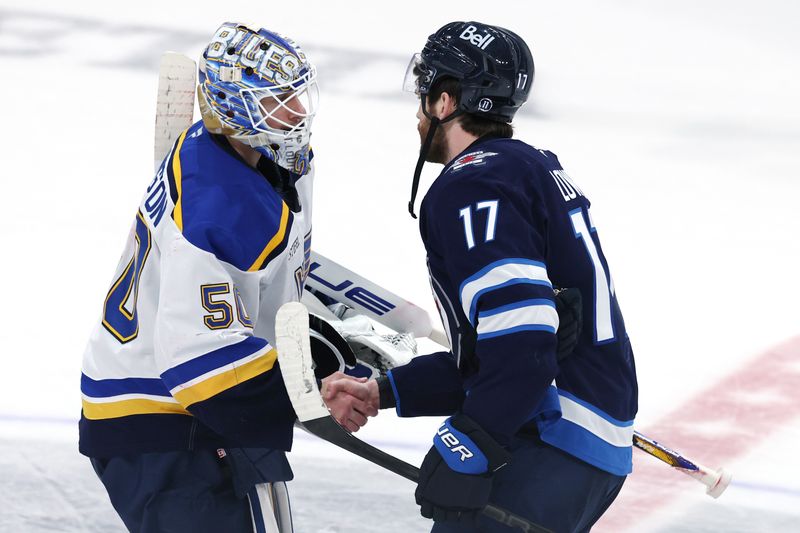 May 4, 2025; Winnipeg, Manitoba, CAN; St. Louis Blues goaltender Jordan Binnington (50) and Winnipeg Jets center Adam Lowry (17) shake hands after the Winnipeg Jets won in double overtime of game seven of the first round of the 2025 Stanley Cup Playoffs at Canada Life Centre. Mandatory Credit: James Carey Lauder-Imagn Images