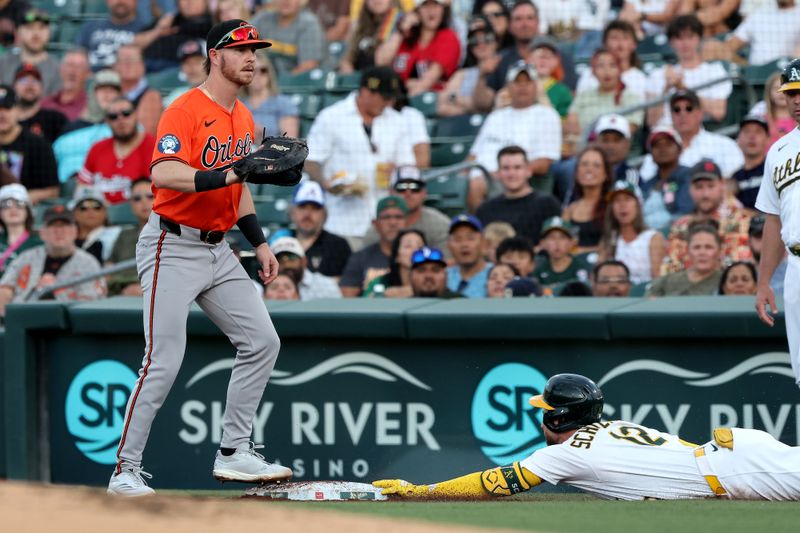 Jun 7, 2025; West Sacramento, California, USA; Athletics second baseman Max Schuemann (12) slides into first base against the Baltimore Orioles during the first inning at Sutter Health Park. Mandatory Credit: Dennis Lee-Imagn Images