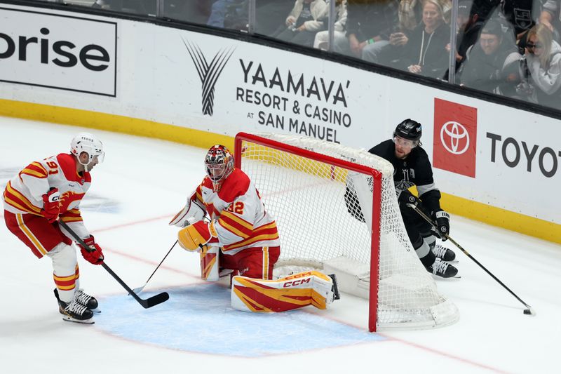 Dec 13, 2025; Los Angeles, California, USA;  Los Angeles Kings right wing Adrian Kempe (9) controls the puck as Calgary Flames goaltender Dustin Wolf (32) defends the goal in overtime at Crypto.com Arena. Mandatory Credit: Kiyoshi Mio-Imagn Images