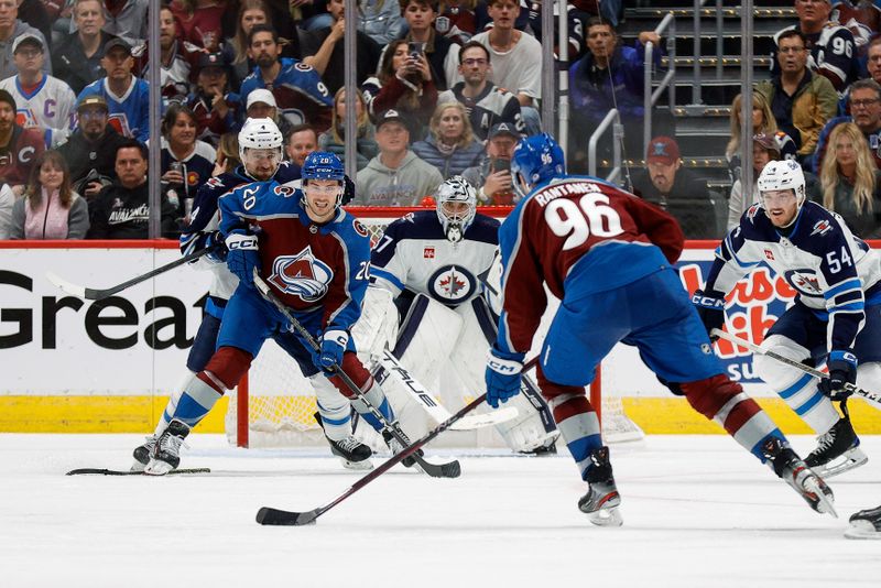 Apr 26, 2024; Denver, Colorado, USA; Colorado Avalanche right wing Mikko Rantanen (96) controls the puck as center Ross Colton (20) screens ahead of Winnipeg Jets defenseman Neal Pionk (4) as goaltender Connor Hellebuyck (37) defends in the third period in game three of the first round of the 2024 Stanley Cup Playoffs at Ball Arena. Mandatory Credit: Isaiah J. Downing-USA TODAY Sports