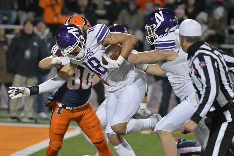 Nov 25, 2023; Champaign, Illinois, USA; Northwestern Wildcats defensive back Garner Wallace (18) runs to the end zone for a touchdown after recovering a fumble by the Illinois Fighting Illini during the second half at Memorial Stadium. Mandatory Credit: Ron Johnson-USA TODAY Sports