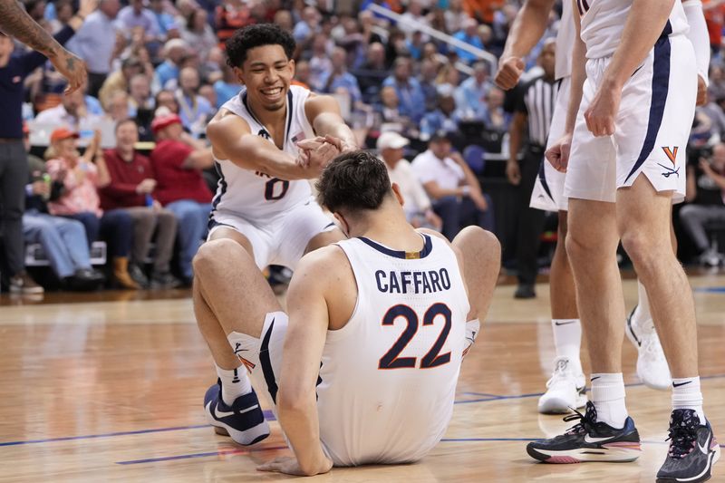 Mar 9, 2023; Greensboro, NC, USA; Virginia Cavaliers guard Kihei Clark (0) helps center Francisco Caffaro (22) up in the first half of the quarterfinals of the ACC tournament at Greensboro Coliseum.  Mandatory Credit: Bob Donnan-USA TODAY Sports