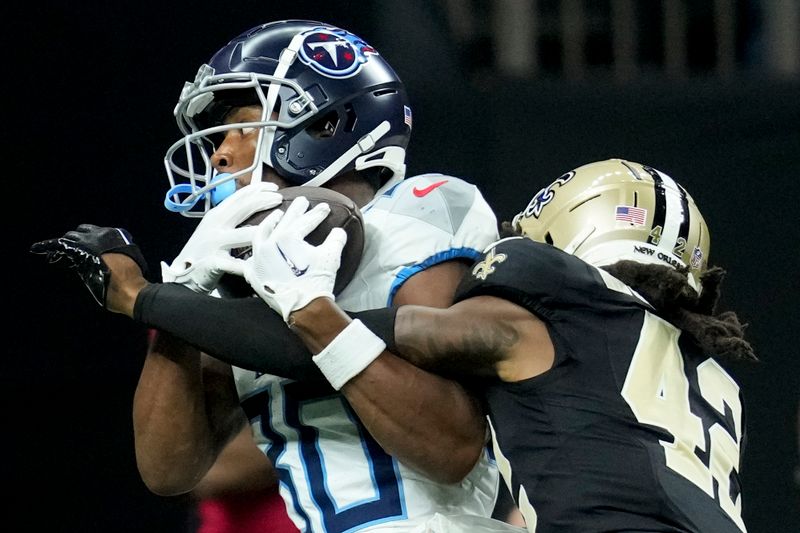 Tennessee Titans wide receiver Bryce Oliver scores in front of New Orleans Saints cornerback Mac McCain III during the second half of an NFL preseason football game, Sunday, Aug. 25, 2024, in New Orleans. (AP Photo/Gerald Herbert)