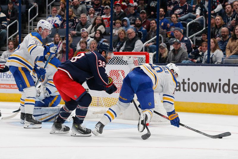 Feb 23, 2024; Columbus, Ohio, USA; Buffalo Sabres defenseman Henri Jokiharju (10) falls to the ice as Columbus Blue Jackets center Boone Jenner (38) draws a penalty during the first period at Nationwide Arena. Mandatory Credit: Russell LaBounty-USA TODAY Sports