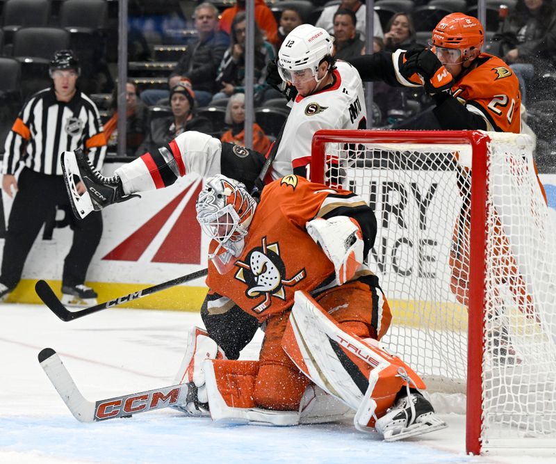 Dec 1, 2024; Anaheim, California, USA;  Anaheim Ducks goaltender Lukas Dostal (1) stops a shot by Ottawa Senators center Shane Pinto (12) with right wing Brett Leason (20) defending at Honda Center. Mandatory Credit: Alex Gallardo-Imagn Images