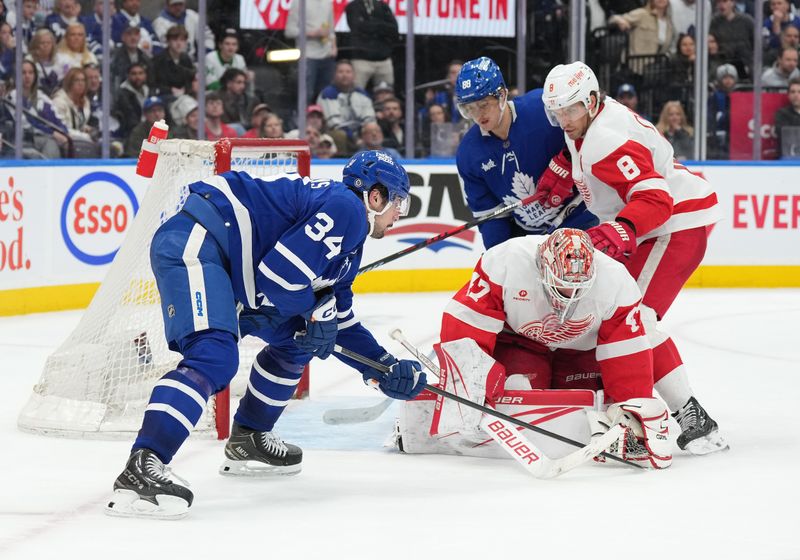 Apr 13, 2024; Toronto, Ontario, CAN; Toronto Maple Leafs center Auston Matthews (34) fights for the rebound as Detroit Red Wings goaltender James Reimer (47) freezes the puck during the third period at Scotiabank Arena. Mandatory Credit: Nick Turchiaro-USA TODAY Sports