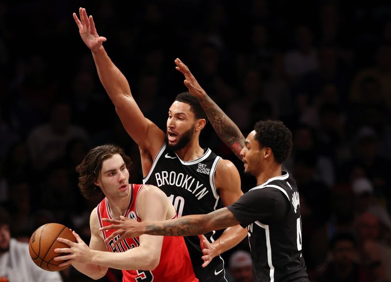 NEW YORK, NEW YORK - NOVEMBER 01: Josh Giddey #3 of the Chicago Bulls looks to pass as Ben Simmons #10 and Keon Johnson #45 of the Brooklyn Nets defend during the second half at Barclays Center on November 01, 2024 in the Brooklyn borough of New York City. The Nets won 120-112. NOTE TO USER: User expressly acknowledges and agrees that, by downloading and or using this photograph, User is consenting to the terms and conditions of the Getty Images License Agreement. (Photo by Sarah Stier/Getty Images)