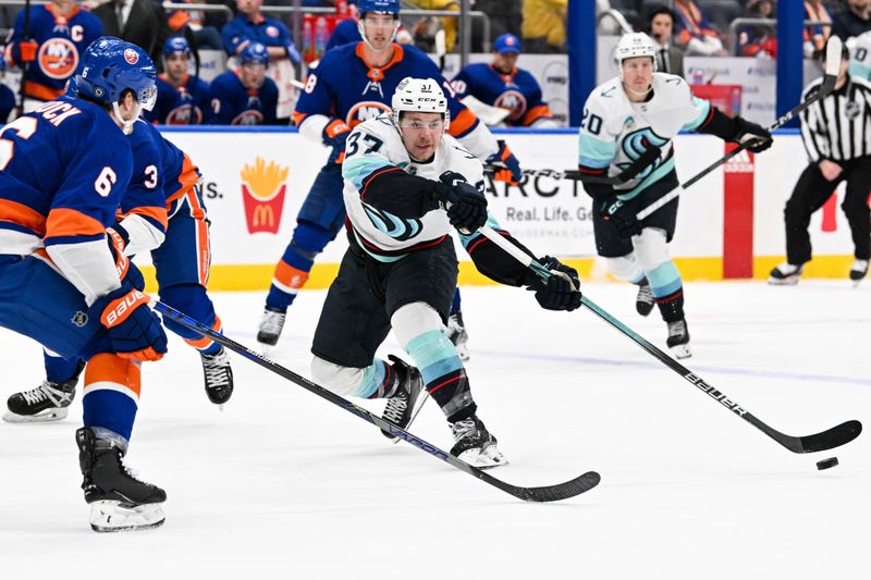 Feb 13, 2024; Elmont, New York, USA; Seattle Kraken center Yanni Gourde (37) attempts a pass defended by New York Islanders defenseman Ryan Pulock (6) during the third period at UBS Arena. Mandatory Credit: Dennis Schneidler-USA TODAY Sports