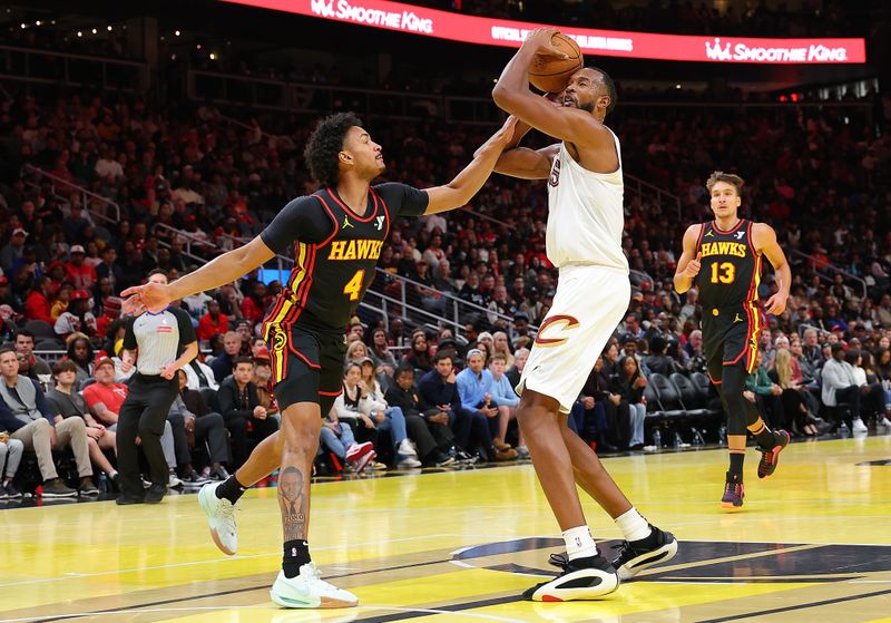 ATLANTA, GEORGIA - NOVEMBER 29:  Evan Mobley #4 of the Cleveland Cavaliers draws a foul from Kobe Bufkin #4 of the Atlanta Hawks during the third quarter of the Emirates NBA Cup game at State Farm Arena on November 29, 2024 in Atlanta, Georgia.  NOTE TO USER: User expressly acknowledges and agrees that, by downloading and/or using this photograph, user is consenting to the terms and conditions of the Getty Images License Agreement.  (Photo by Kevin C. Cox/Getty Images)