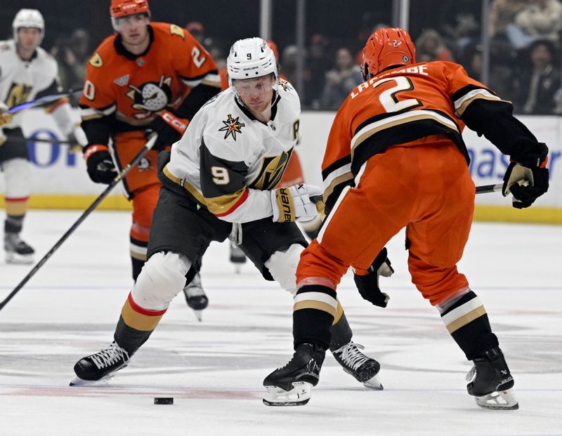 Dec 4, 2024; Anaheim, California, USA;  Vegas Golden Knights center Jack Eichel (9) controls the puck against Anaheim Ducks defenseman Jackson LaCombe (2) during the third period at Honda Center. Mandatory Credit: Alex Gallardo-Imagn Images