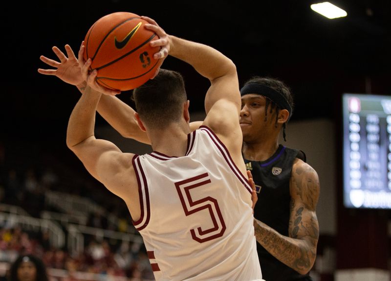 Feb 26, 2023; Stanford, California, USA; Washington Huskies guard Koren Johnson (0) defends against Stanford Cardinal guard Michael O'Connell (5) during the second half at Maples Pavilion. Mandatory Credit: D. Ross Cameron-USA TODAY Sports