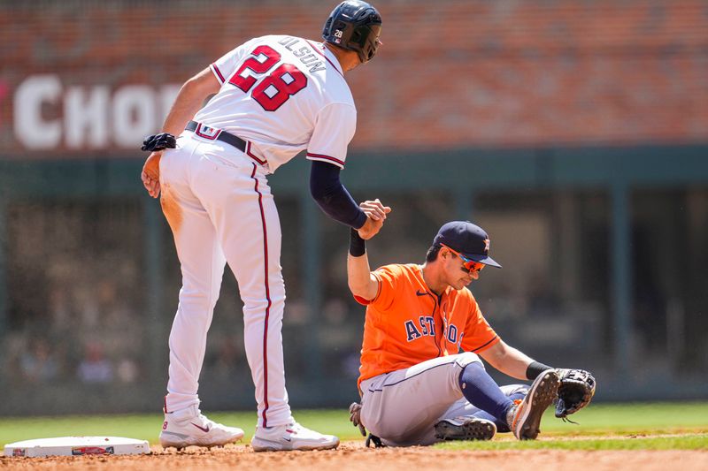 Apr 23, 2023; Cumberland, Georgia, USA; Atlanta Braves first baseman Matt Olson (28) helps up Houston Astros second baseman Mauricio Dubon (14) after a collision during the sixth inning at Truist Park. Mandatory Credit: Dale Zanine-USA TODAY Sports