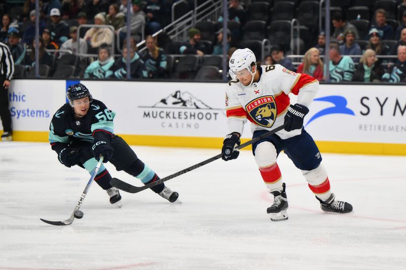 Dec 12, 2023; Seattle, Washington, USA; Seattle Kraken right wing Kailer Yamamoto (56) steals the puck from Florida Panthers defenseman Brandon Montour (62) during the second period at Climate Pledge Arena. Mandatory Credit: Steven Bisig-USA TODAY Sports