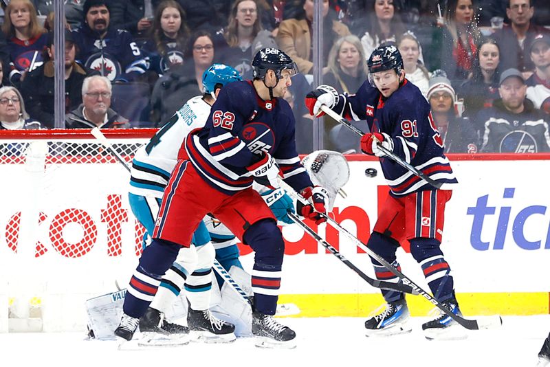 Feb 14, 2024; Winnipeg, Manitoba, CAN; Winnipeg Jets Nino Niederreiter (62) and Winnipeg Jets center Cole Perfetti (91) eye an incoming shot on San Jose Sharks goaltender Kaapo Kahkonen (36) on the first period at Canada Life Centre. Mandatory Credit: James Carey Lauder-USA TODAY Sports