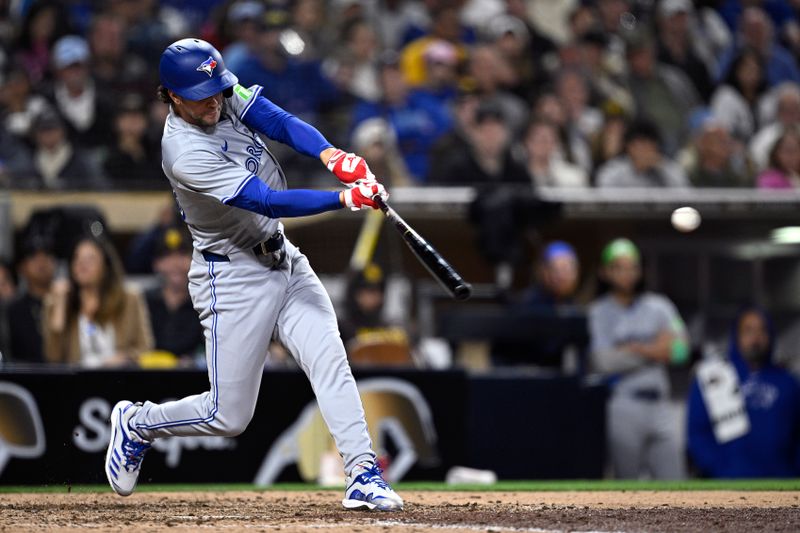 Apr 20, 2024; San Diego, California, USA; Toronto Blue Jays third baseman Ernie Clement (28) hits an RBI single against the San Diego Padres during the ninth inning at Petco Park. Mandatory Credit: Orlando Ramirez-USA TODAY Sports