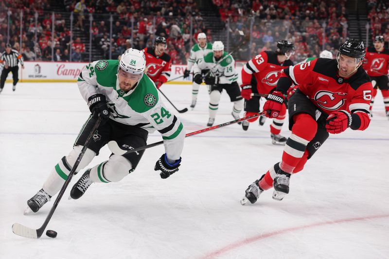 Dec 3, 2025; Newark, New Jersey, USA; Dallas Stars center Roope Hintz (24) skates with the puck as New Jersey Devils defenseman Brenden Dillon (5) defends during the first period at Prudential Center. Mandatory Credit: Ed Mulholland-Imagn Images