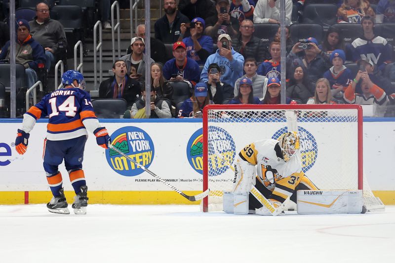 Nov 5, 2024; Elmont, New York, USA; New York Islanders center Bo Horvat (14) scores a goal against Pittsburgh Penguins goaltender Alex Nedeljkovic (39) during the shootout at UBS Arena. Mandatory Credit: Brad Penner-Imagn Images