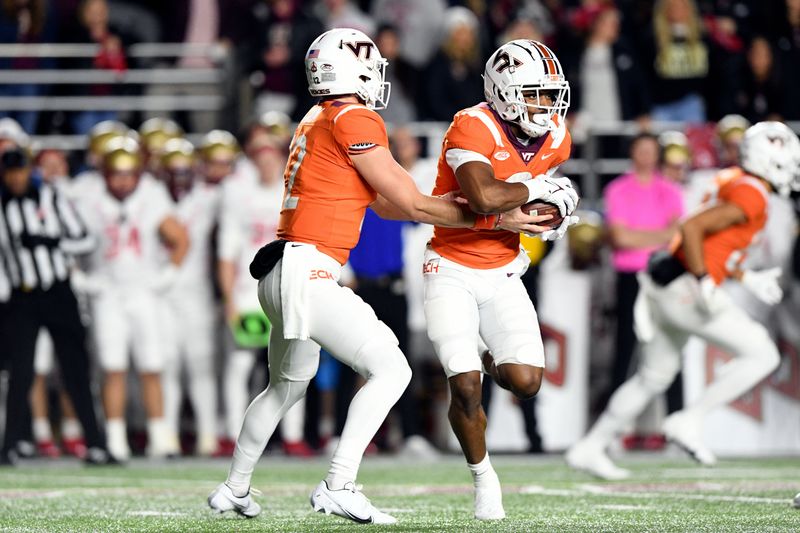 Nov 5, 2021; Chestnut Hill, Massachusetts, USA; Virginia Tech Hokies quarterback Knox Kadum (12) hands the ball off to wide receiver Tayvion Robinson (9) during the first half at Alumni Stadium. Mandatory Credit: Brian Fluharty-USA TODAY Sports