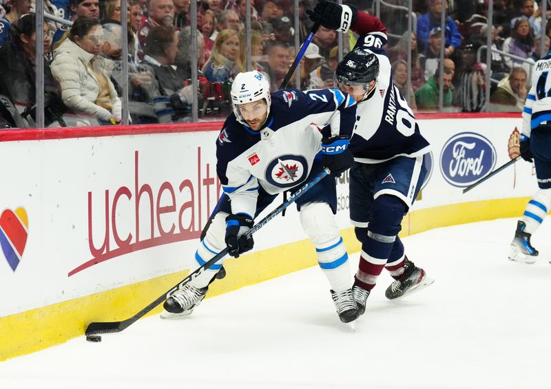 Dec 7, 2023; Denver, Colorado, USA; Colorado Avalanche right wing Mikko Rantanen (96) and Winnipeg Jets defenseman Dylan DeMelo (2) battle for the puck in the second period at Ball Arena. Mandatory Credit: Ron Chenoy-USA TODAY Sports